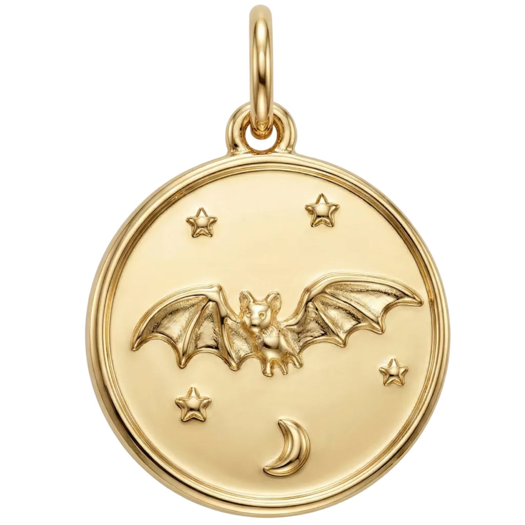 Gold pendant with a bat design on a white background