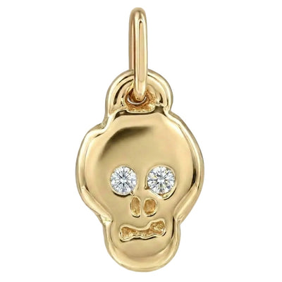 Gold skull pendant with embedded diamonds on a white background
