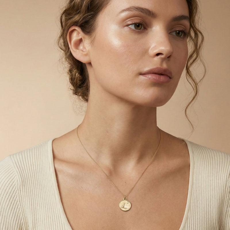 Woman wearing a gold necklace against a beige background